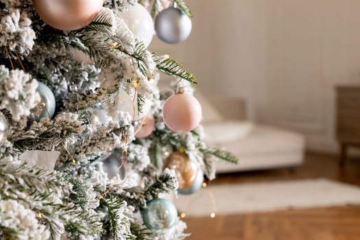 Christmas holiday composition. Christmas tree fir branches, silver balls on top border on pink pastel background with copy space.
