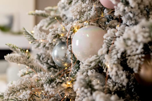 Christmas holiday composition. Christmas tree fir branches, silver balls on top border on pink pastel background with copy space.