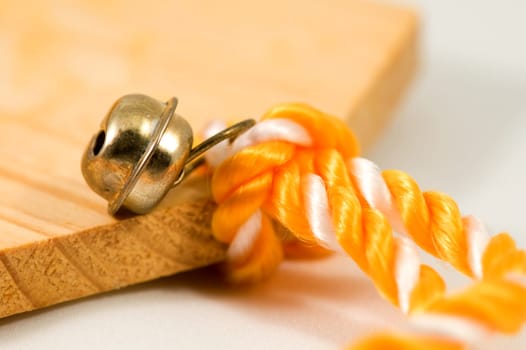 Closeup of decorative bronze bell on orange rope