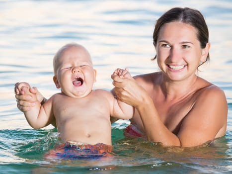 Baby and mother having fun time in the sea