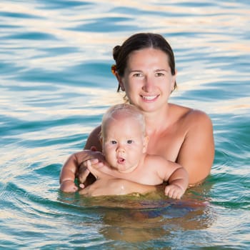 Baby and mother having fun time in the sea