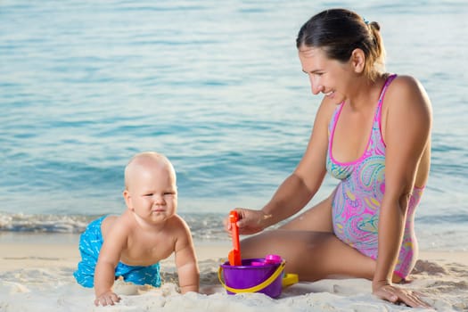 Baby and mom are playing beach toys