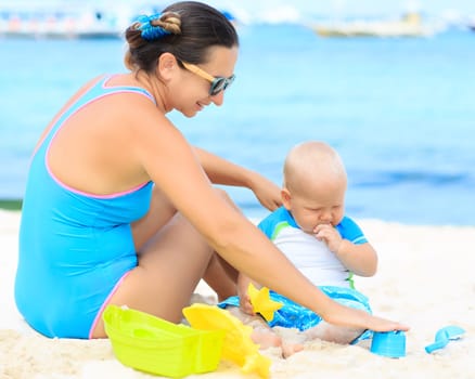 Baby and mom are playing beach toys