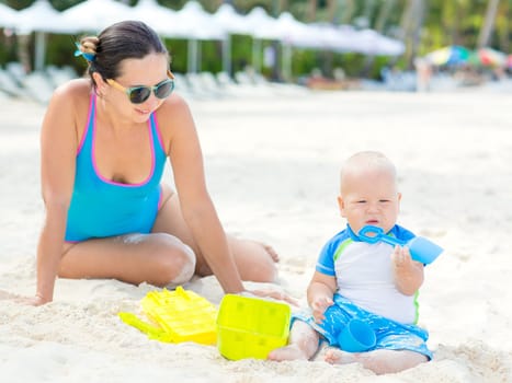 Baby and mom are playing beach toys