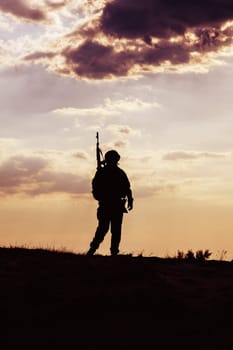 Silhouette of US soldier with rifle against the sunset