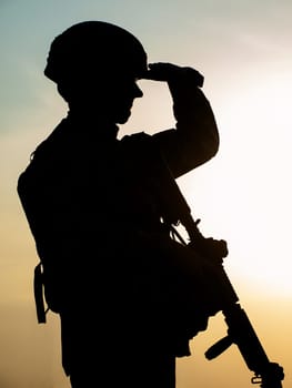 Silhouette of US soldier with rifle against the sunset