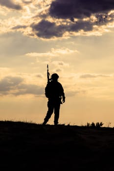 Silhouette of US soldier with rifle against the sunset