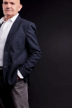 old bald self-confident businessman on a dark background
