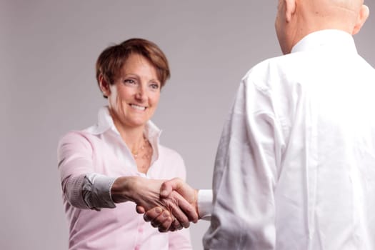 a happy senior woman handshaking