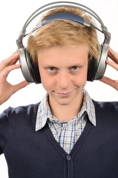 Confident teenage boy listening to music with headphones isolated