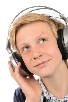 Thoughtful teenage boy with headphones listening to music isolated