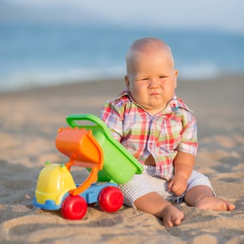Cute baby is playing toy car