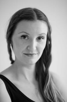 Closeup black and white studio portrait of relaxed looking attractive woman wearing dark blouse