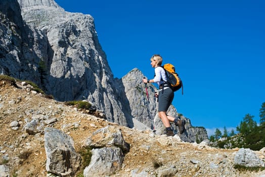 Young woman with backpack hiking in mountains