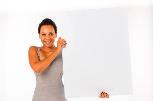 Beautiful young woman holding and showing a white billboard with copy space, isolated on white background.