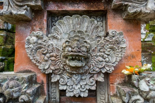 Artful carvings in stone stonemasonry in a green complex in Bali