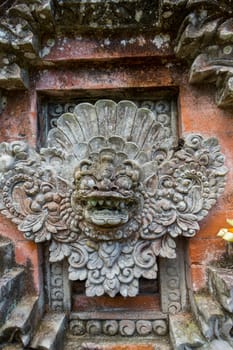 Artful carvings in stone stonemasonry in a green complex in Bali
