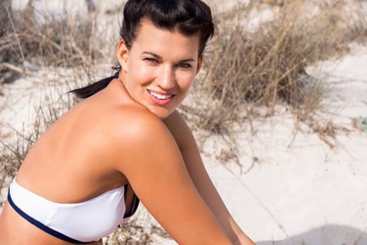 Young attractive woman in bikini in summer on the beach on vacation with blue hommel