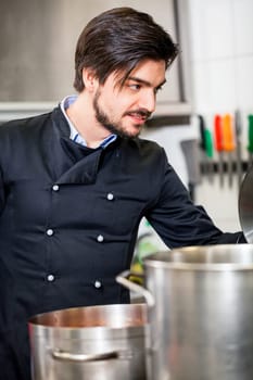 young adult chekoch in the restaurant kitchen at the herd while cooking