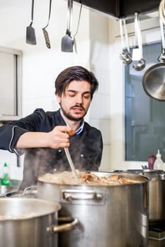 young adult chekoch in the restaurant kitchen at the herd while cooking