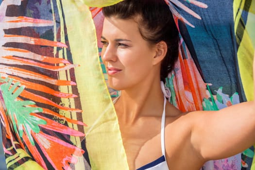 Young pretty woman with dark hair in bikini and Pareo on vacation on the beach portrait