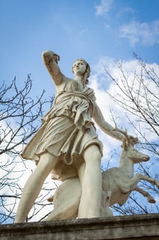 Statue of stone marble carved in front of blue sky in Paris