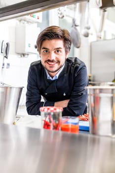 young adult chef in the restaurant kitchen while cooking at the herd preparation