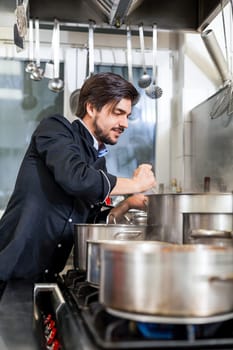 young adult chekoch in the restaurant kitchen at the herd while cooking