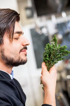 young chef in the restaurant kitchen with fresh arümatic spices