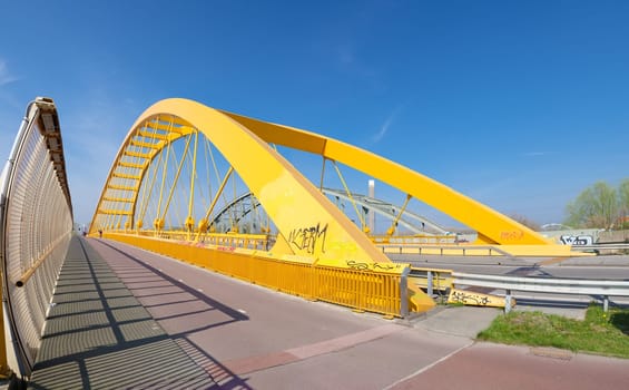 yellow arch bridge in Utrecht, netherlands. The Hogeweide Bridge is a steel arch bridge over the Amsterdam-Rhine Canal