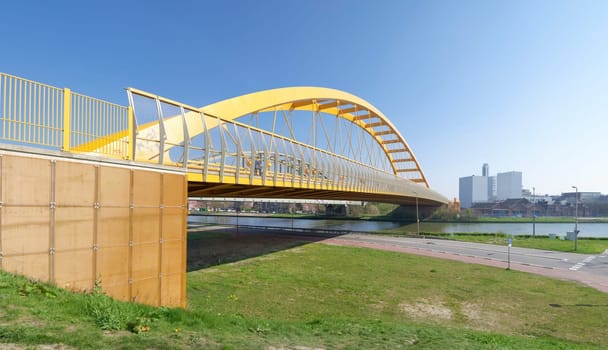 yellow arch bridge in Utrecht, netherlands. The Hogeweide Bridge is a steel arch bridge over the Amsterdam-Rhine Canal