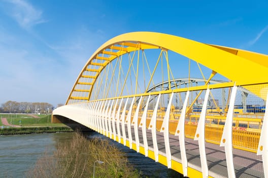 yellow arch bridge in Utrecht, netherlands. The Hogeweide Bridge is a steel arch bridge over the Amsterdam-Rhine Canal