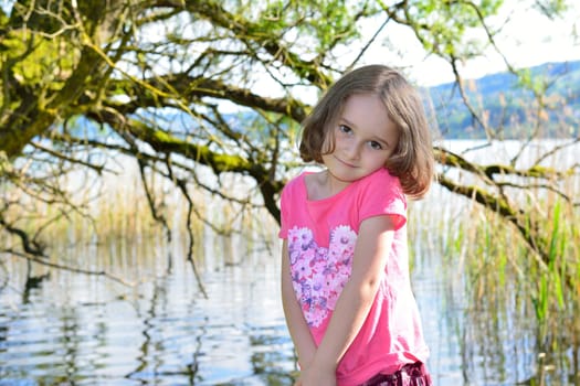 Little girl posing in front of a lake