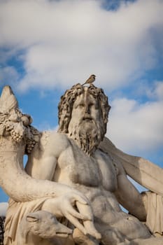 Statue of stone marble carved in front of blue sky in Paris