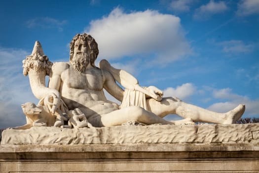 Statue of stone marble carved in front of blue sky in Paris