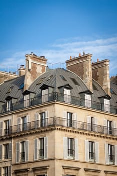 Exterior view of a Parisian townhouse in summer in front of a blue sky