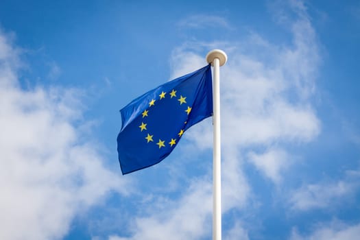 European flag on a flagpole in front of a blue sky