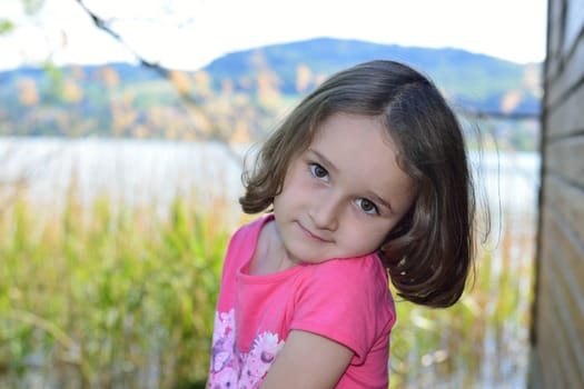 Little girl posing in front of a lake