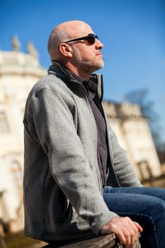 Trendy senior man with sporty clothes relaxes in the outdoors in the sun