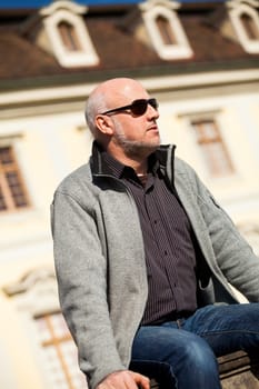 Trendy senior man with sporty clothes relaxes in the outdoors in the sun