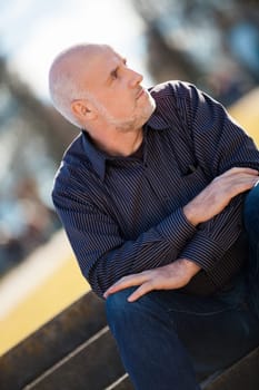 Man middle-aged senior pensioner taking a break in the outdoor park