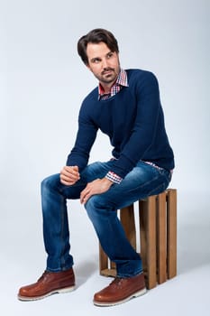 Young man with beard and dark hair with jeans and carated shirt