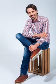 Young man with beard and dark hair with jeans and carated shirt