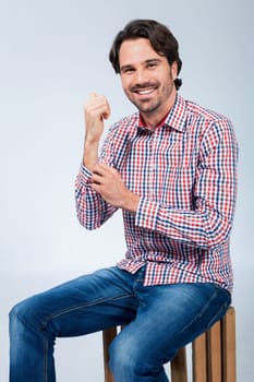 Young man with beard and dark hair with jeans and carated shirt