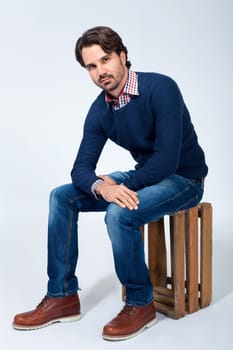 Young man with beard and dark hair with jeans and carated shirt
