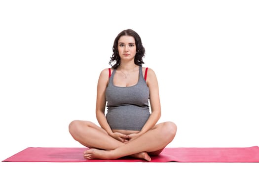 Attractive pregnant young woman makes yoga isolated against white background