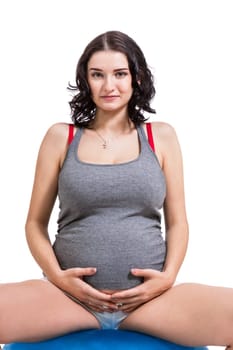 Attractive pregnant woman on a blue gymnastics ball to prepare for the brew