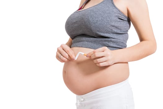 Pregnant woman breaks a cigarette in front of her baby belly isolated against white background