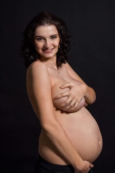 Young pregnant woman with baby belly naked in front of black butt