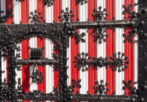 red with white medieval door with metal decorations on it